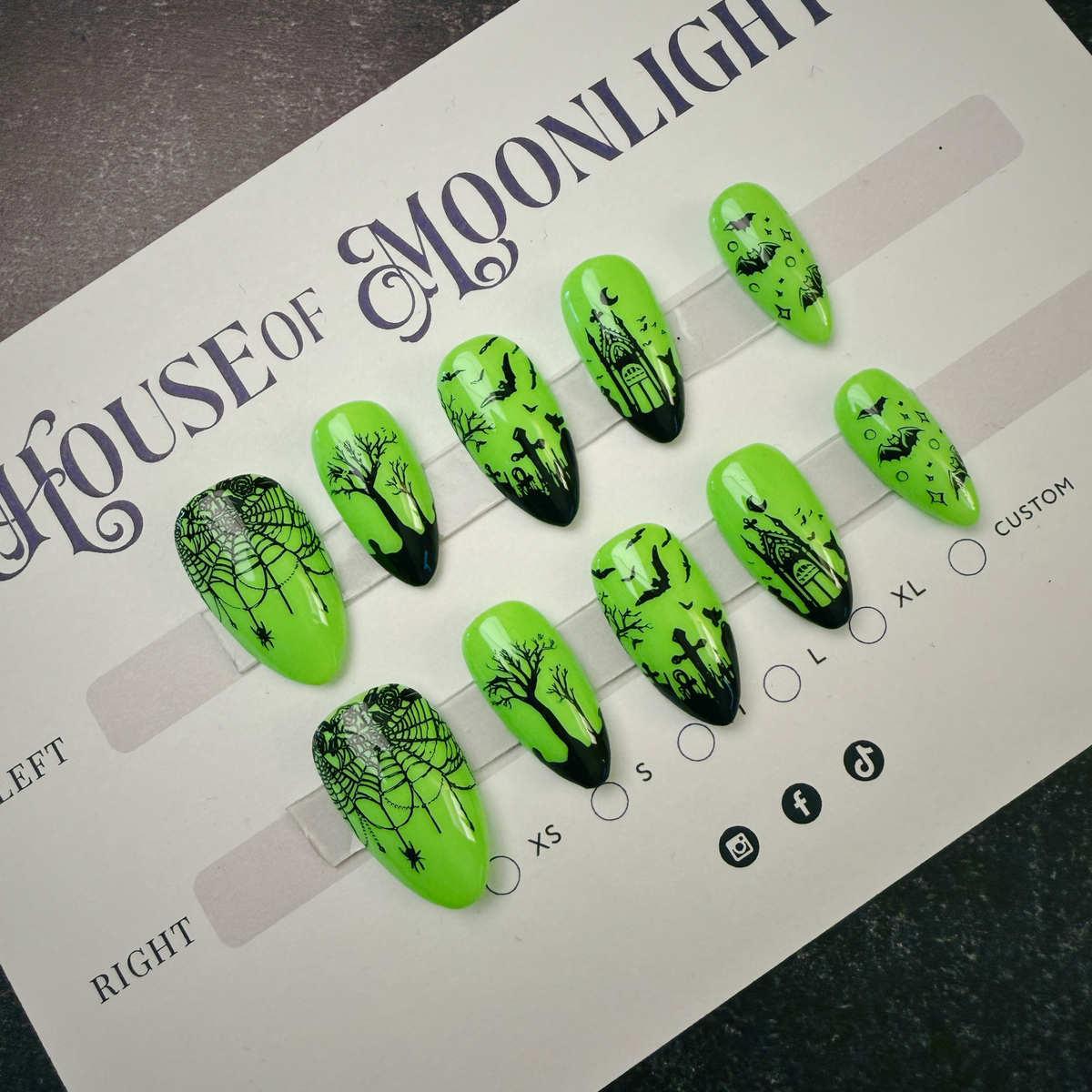 A set of bright neon green press-on nails with black spooky Halloween designs, displayed on a white sizing card labeled 'HOUSE OF MOONLIGHT'.